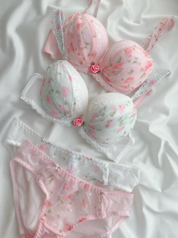 Set of pink and white floral lingerie on a white background